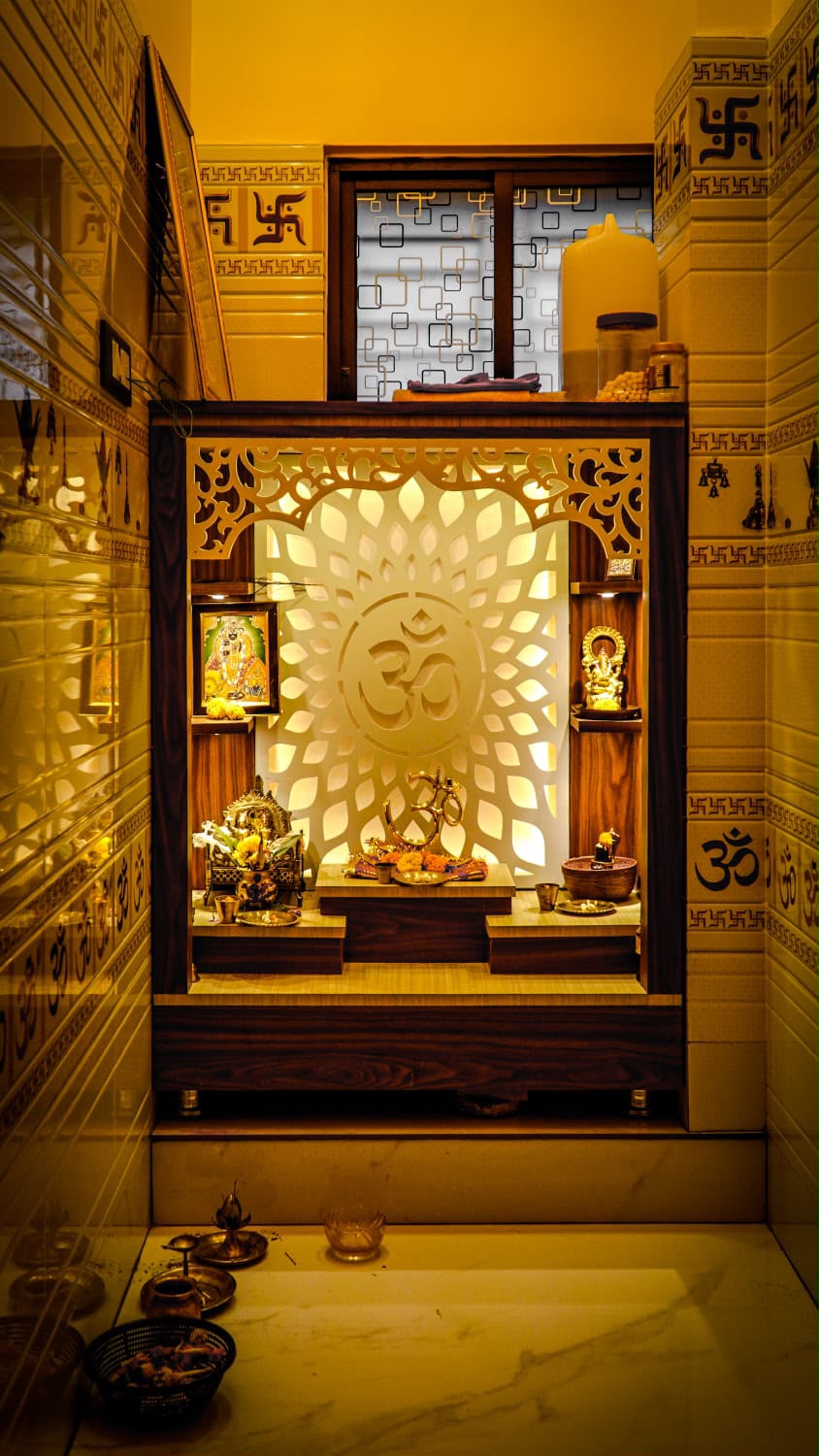Custom pooja unit with carved jaali and warm lighting