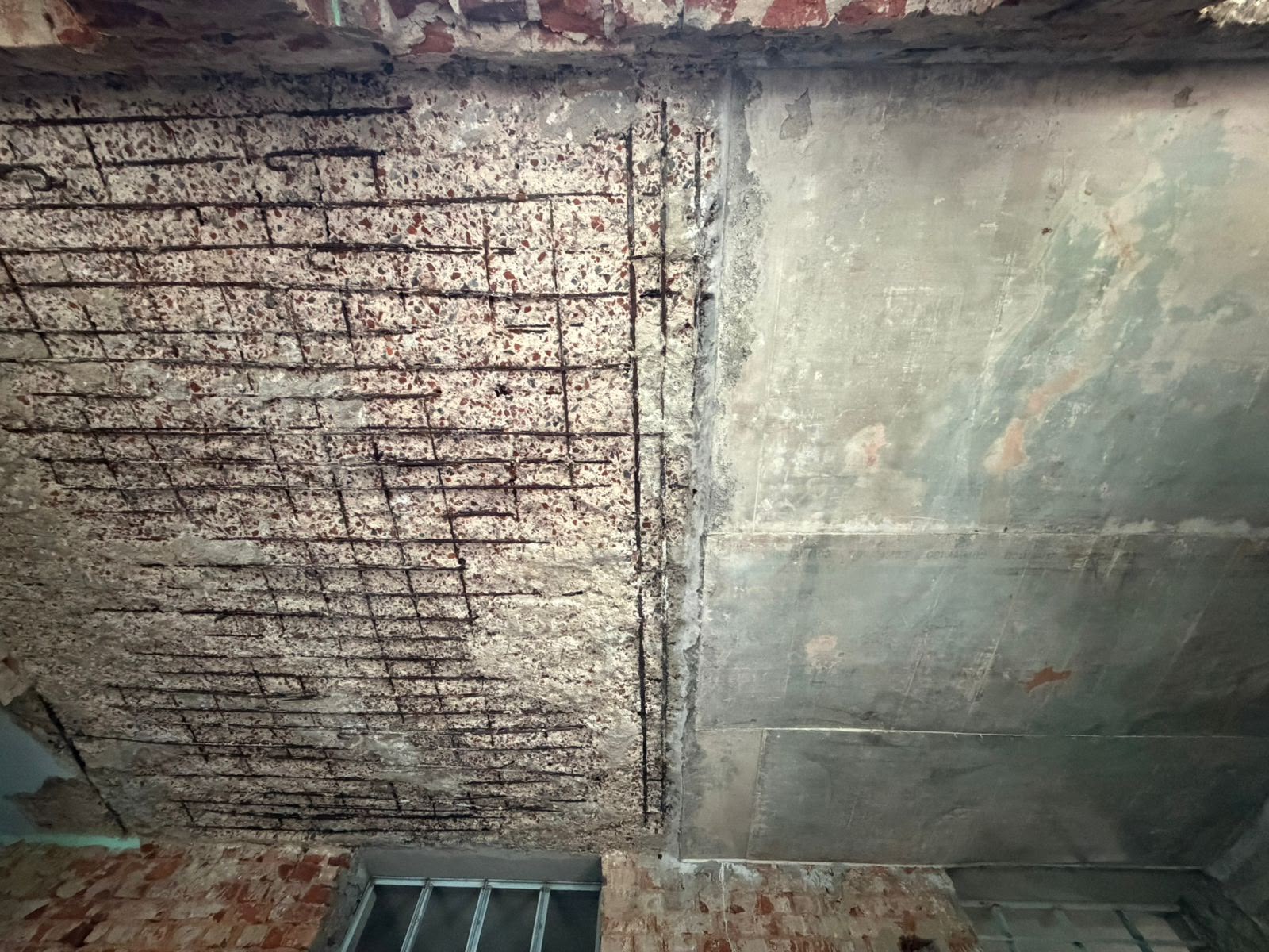 Exposed reinforcement and damaged concrete wall during structural repair