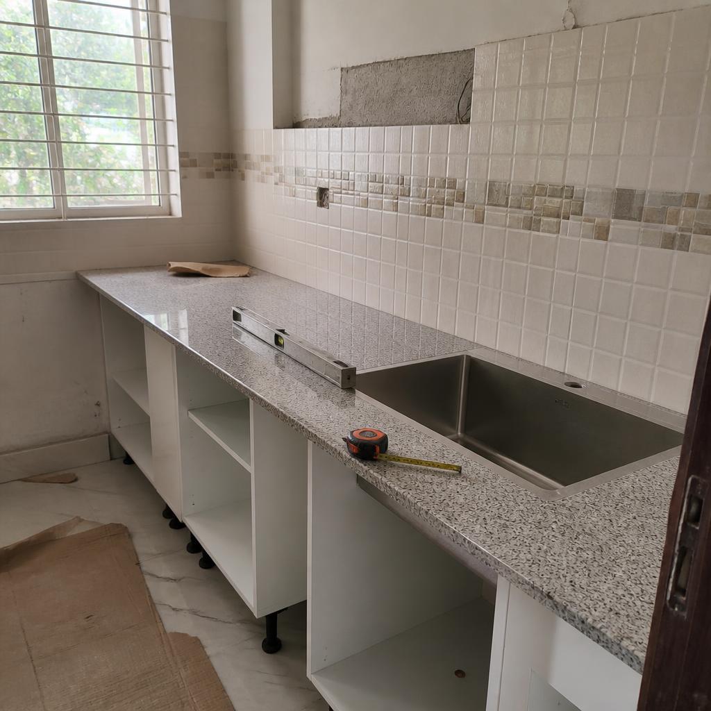 Granite counter and cabinets being installed during a kitchen renovation
